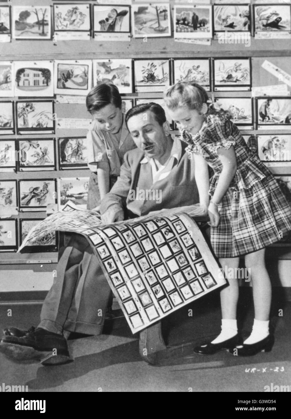 Walt Disney présente 2 jeunes acteurs, Bobby Driscoll (à gauche), et Luana Patten (à droite) les story-boards pour sa nouvelle production, 'chant du Sud." Banque D'Images