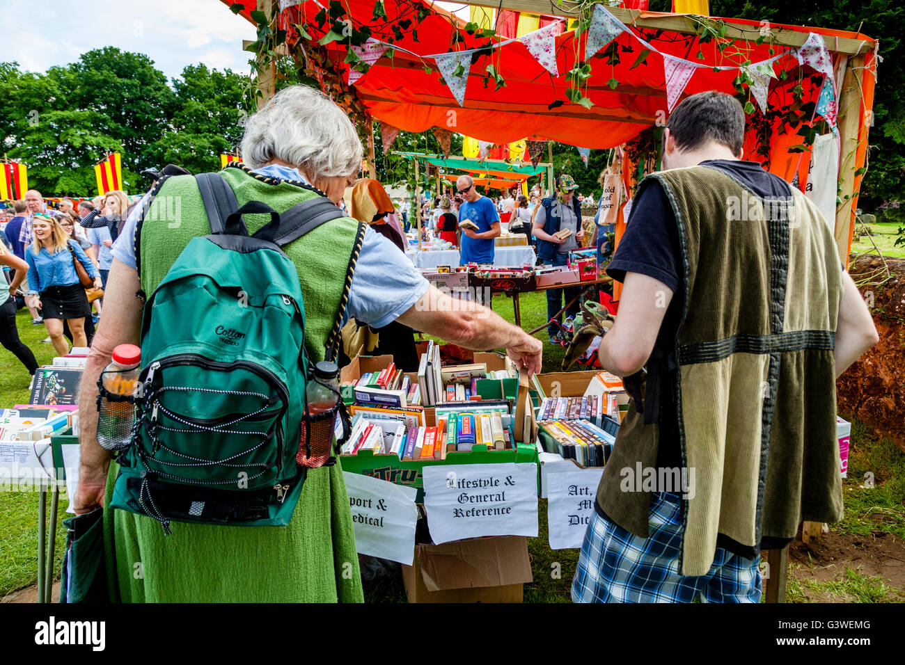 La population locale, en costume d'occasion de choisir des livres au kiosque à la Foire Médiévale de Abinger, Surrey, UK Banque D'Images