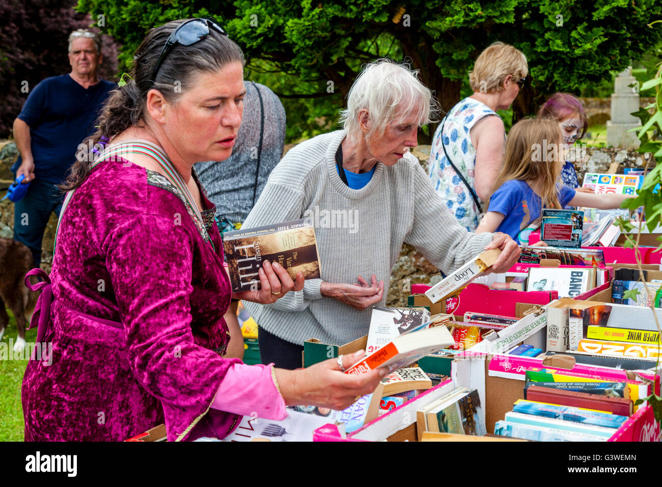 Les personnes ayant choisi de livres d'occasion le kiosque à la Foire Médiévale de Abinger, Surrey, UK Banque D'Images