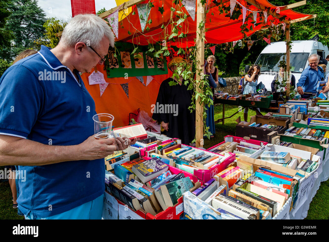 Un homme choisit des livres d'occasion du kiosque à la Foire Médiévale de Abinger, Surrey, UK Banque D'Images