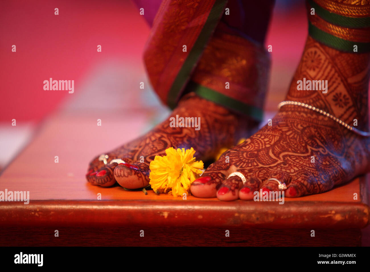 Un rituel lors d'un mariage traditionnel Indien avec une fleur de souci gardé près de les mariées pieds. Banque D'Images