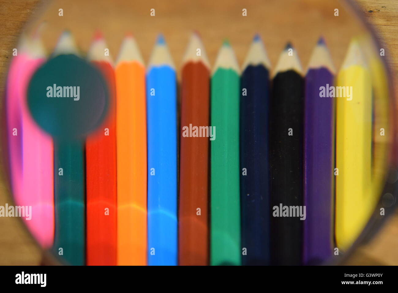 Des crayons de couleur à travers une loupe Banque D'Images