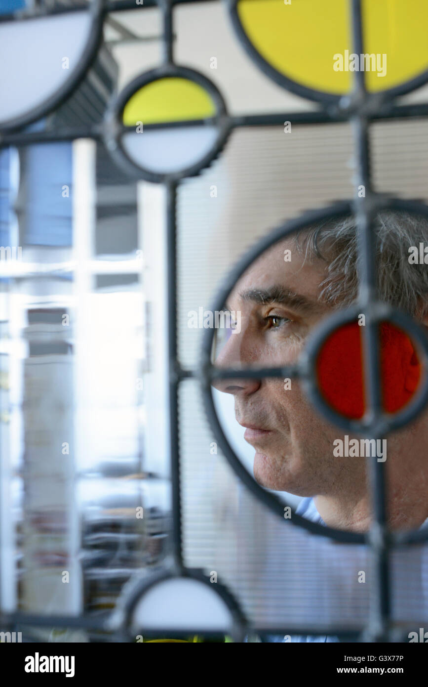 Portrait d'artisan verrier Phil Daniel avec l'un de ses panneaux de verre. Banque D'Images