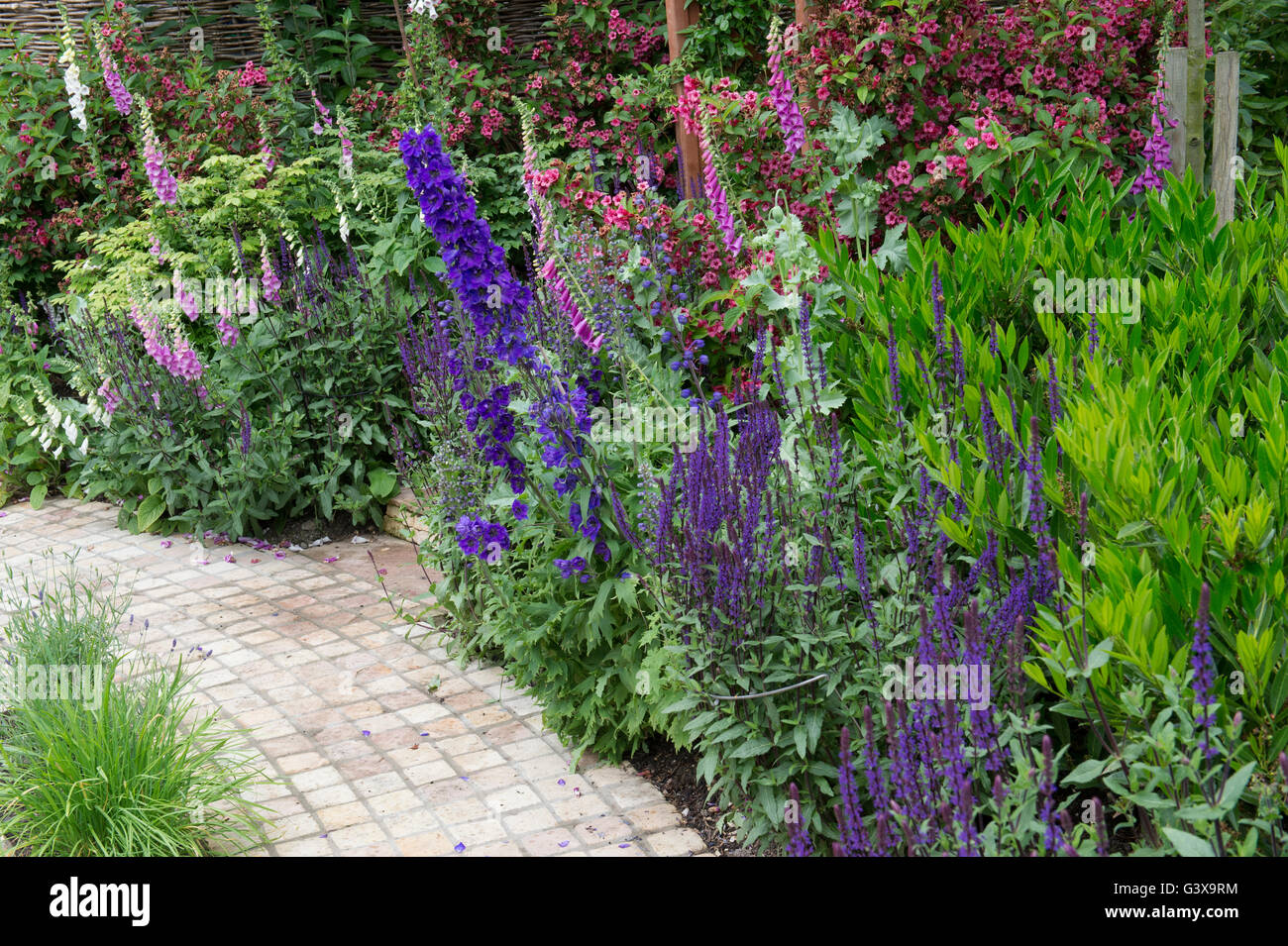 Fleur - frontière et bloquer pavage dans un cottage anglais jardin. En vertu de l'Ashton Hill, Wychavon, Worcestershire, Angleterre. Banque D'Images