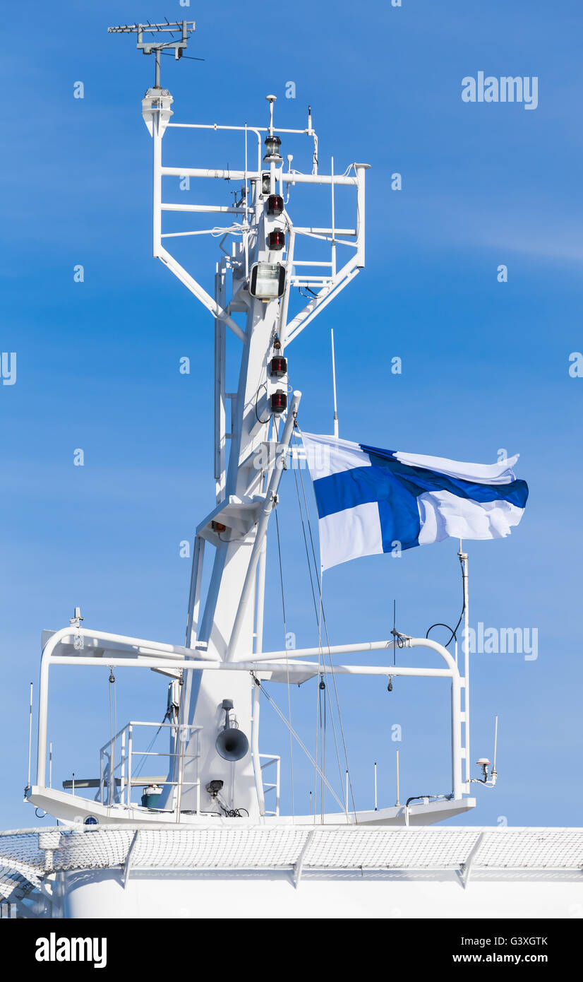 Bateau blanc mât avec drapeau national de la Finlande sur fond de ciel bleu Banque D'Images