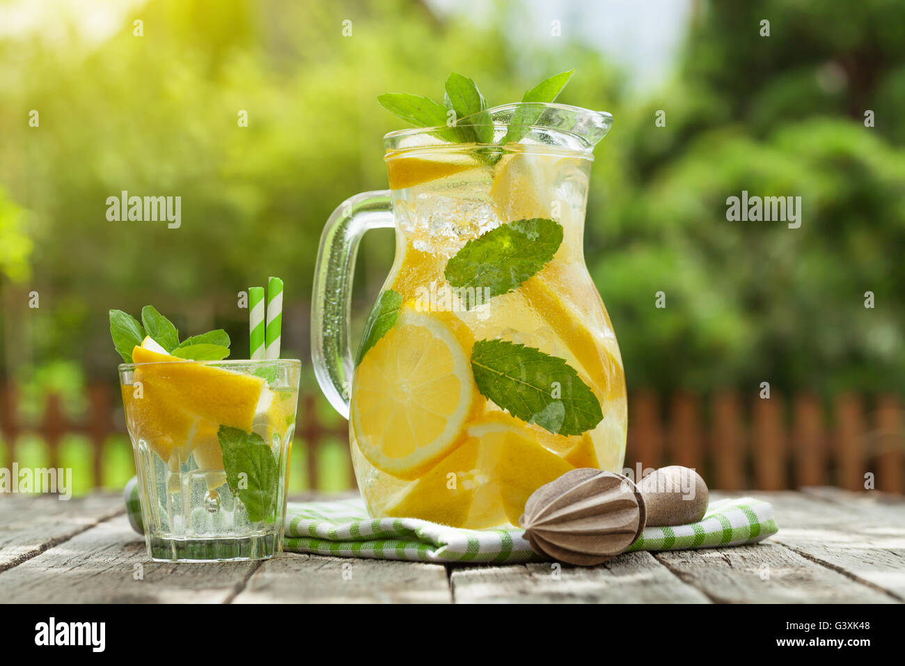 Pichet en verre de limonade et de citron, de menthe et de la glace sur la  table de jardin Photo Stock - Alamy