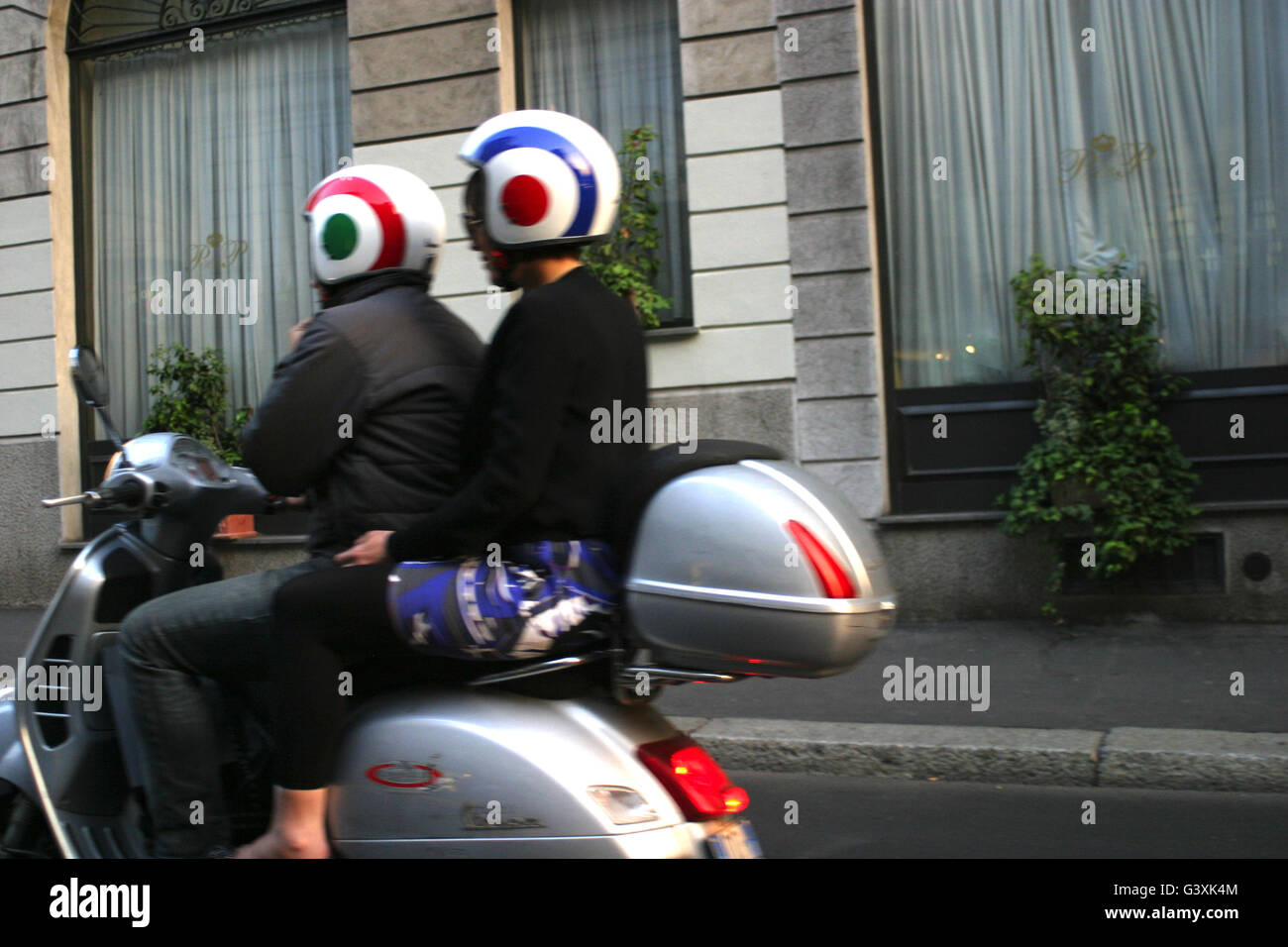 La nouvelle vespa scooter avec 2 passagers avec casque élégant, en passant par Milan, Italie Banque D'Images