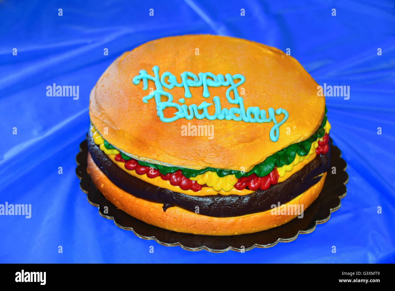 Joyeux Anniversaire Gateau Dans Une Forme D Un Hamburger Sur La Nappe De Plastique Bleu Photo Stock Alamy