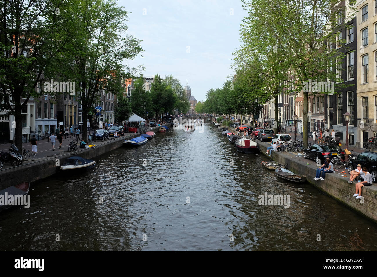 D'un canal à Amsterdam, les gens assis par l'eau Banque D'Images