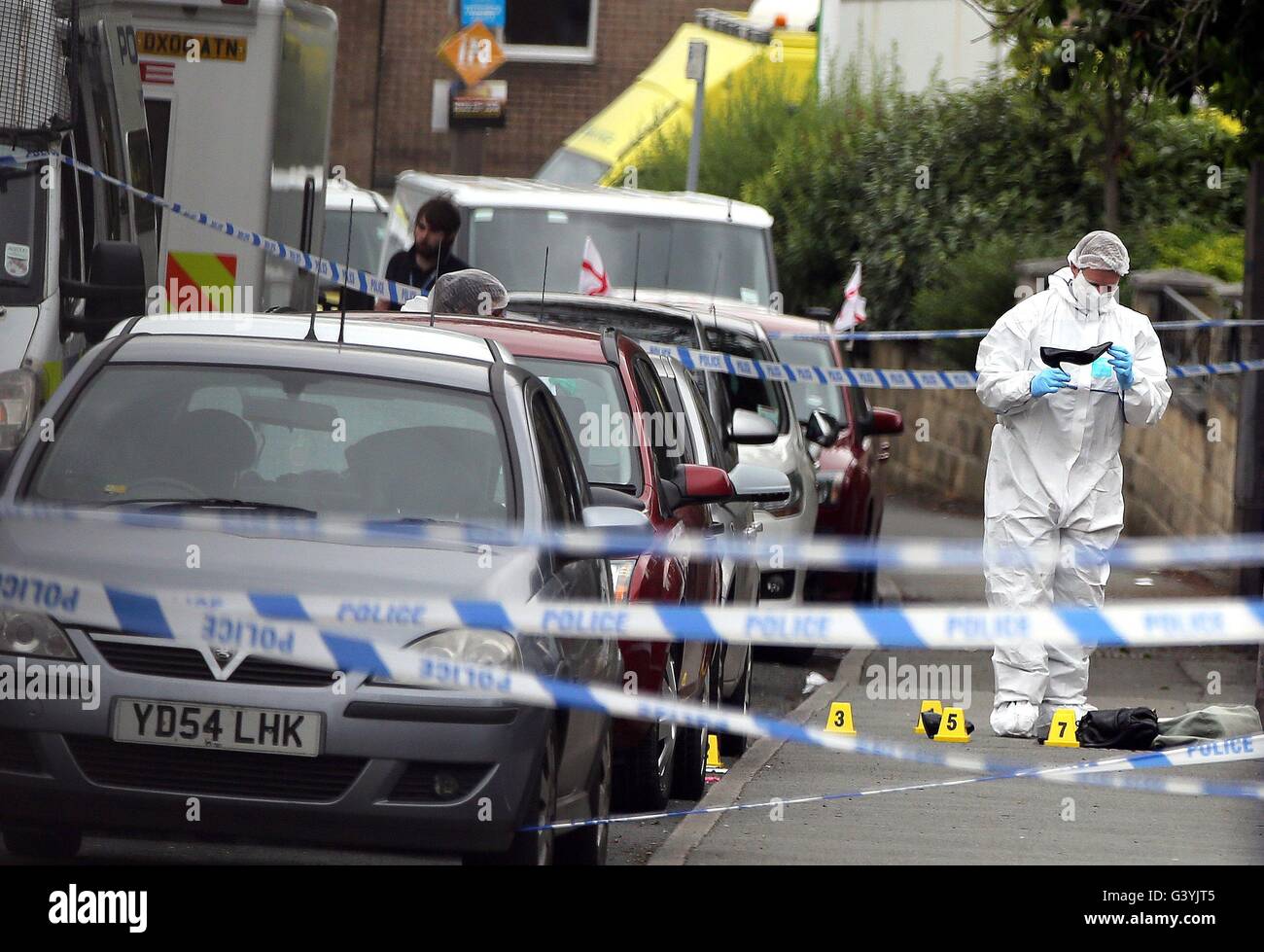 Un agent de police scientifique regarde une femme de service sur les lieux en Birstall, West Yorkshire, après la mort du travail MP Jo Cox, qui est mort après avoir été abattu et poignardé dans la rue à l'extérieur de sa circonscription conseils la chirurgie. Banque D'Images
