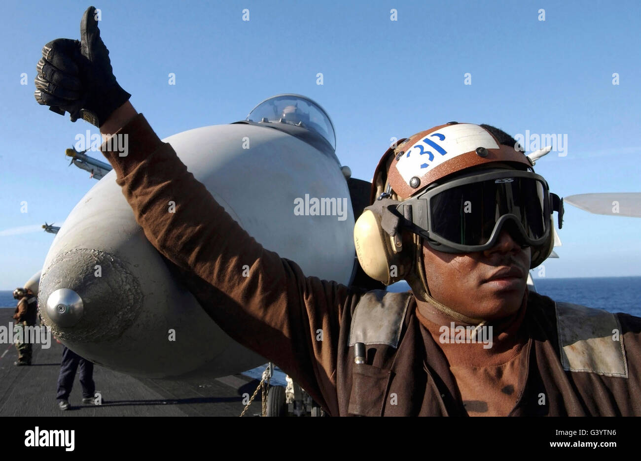 Un aviateur thumbs-up donne un signal à l'envol du personnel. Banque D'Images