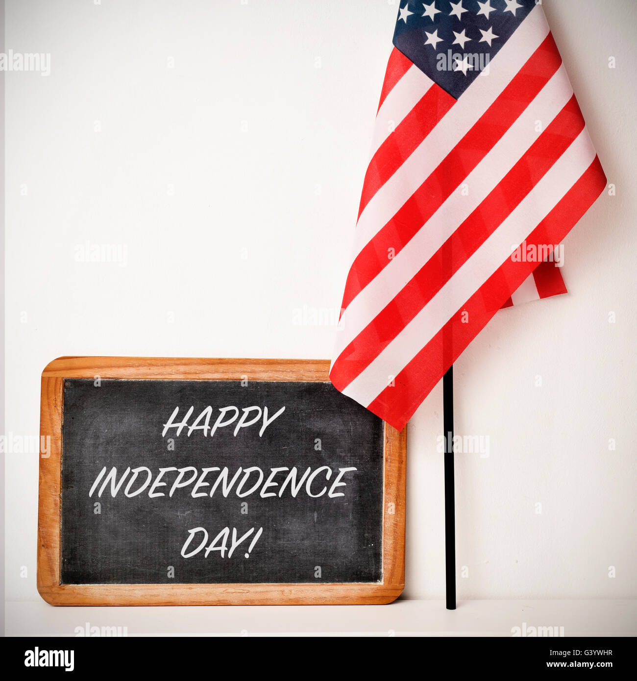 Un tableau en bois avec la joyeuse fête de l'indépendance du texte écrit en C et un drapeau des États-Unis, sur une zone blanche Banque D'Images