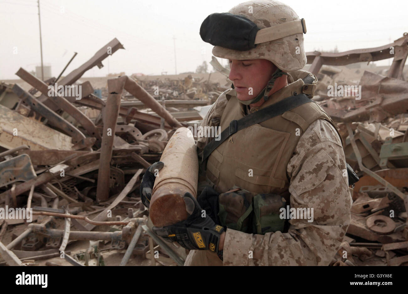 Un soldat porte un tour d'artillerie de 155 millimètres non utilisés. Banque D'Images