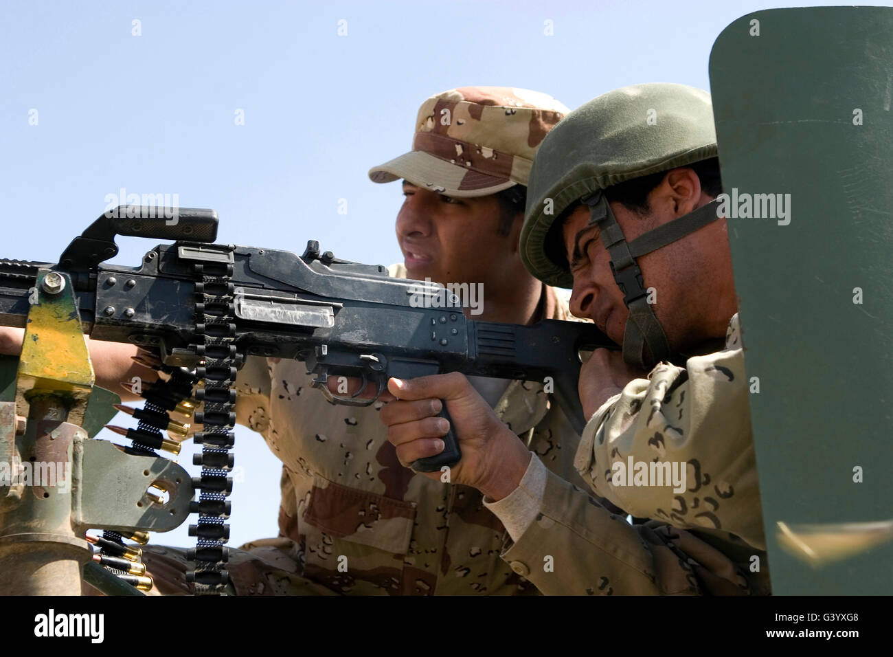 Un instructeur de l'armée iraquienne supervise un soldat de l'armée irakienne avec un PKM 7,62 mm machine gun. Banque D'Images