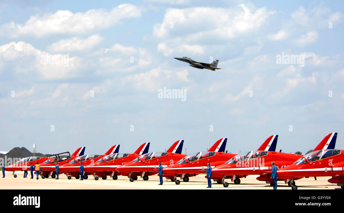 Un F-15 Eagle vole au-dessus de l'équipe de voltige aérienne de la Royal Air Force, les flèches rouges. Banque D'Images
