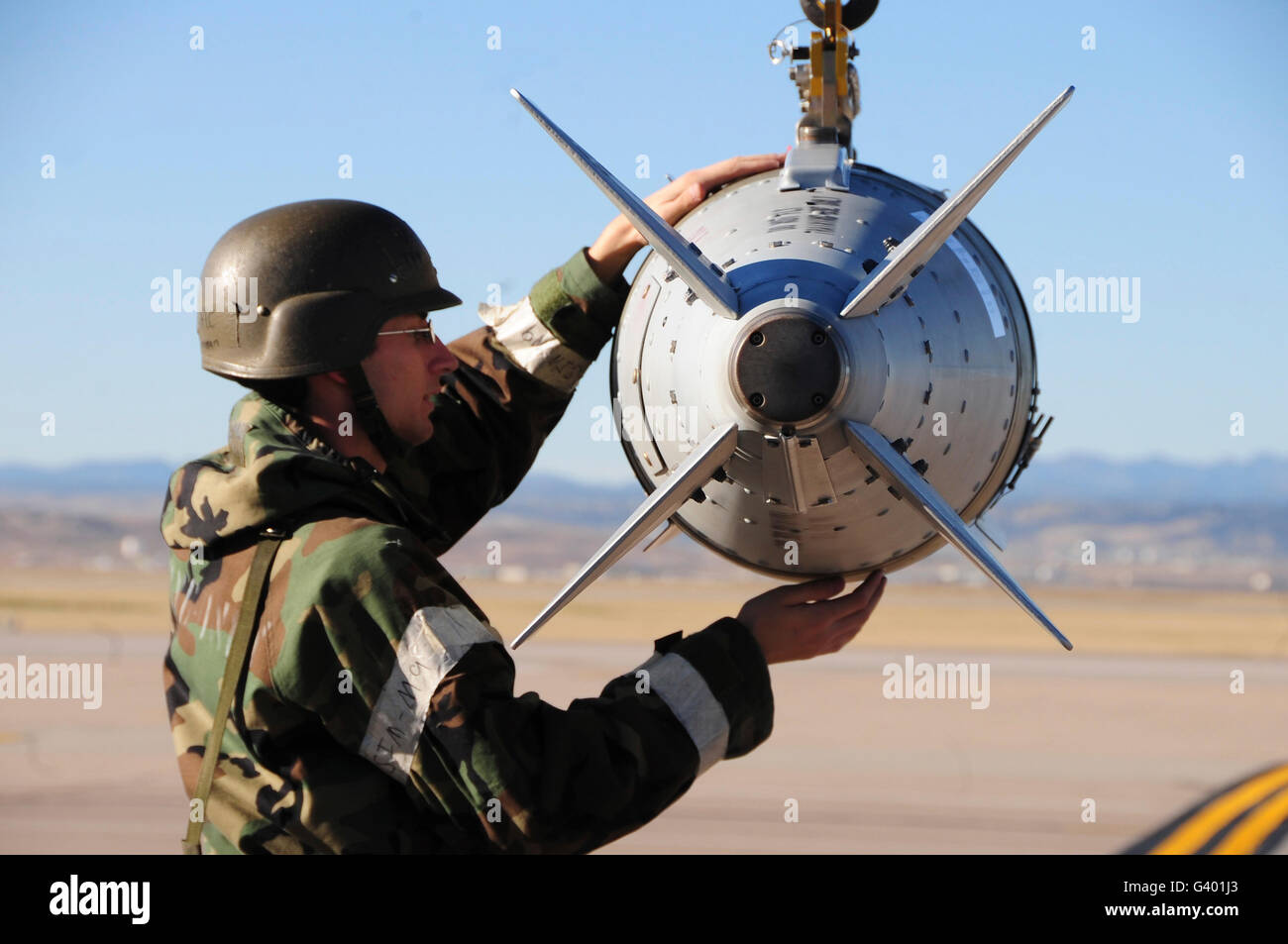 Un aviateur garantit une GBU-31 Joint Direct Attack Munition est fixé sur une bombe d'ascenseur. Banque D'Images