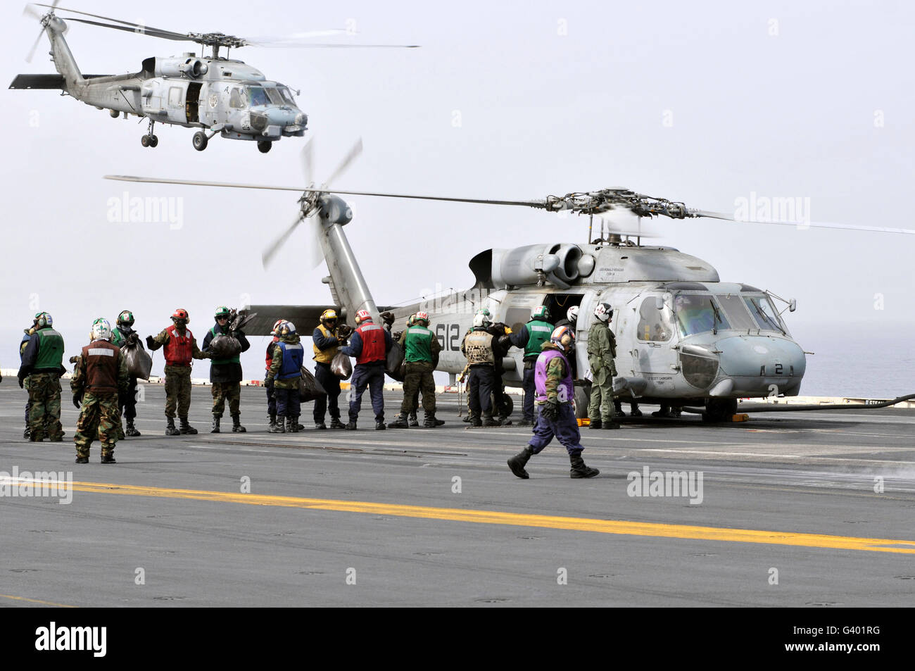 Charge le personnel de fournitures humanitaires sur un SH-60F Sea Hawk. Banque D'Images