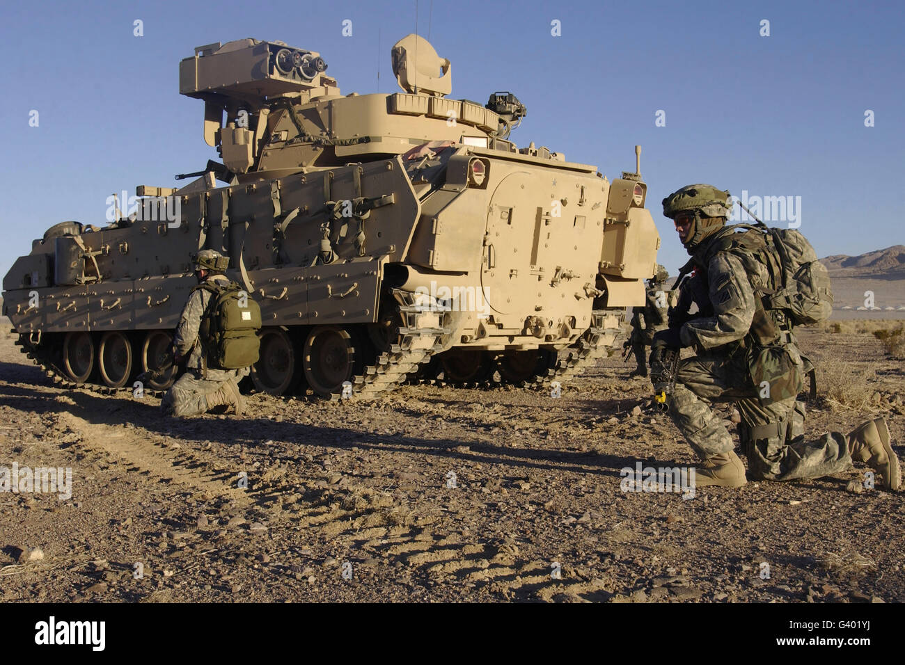 Les soldats de l'armée américaine d'assurer la sécurité d'un véhicule de combat Bradley M2. Banque D'Images