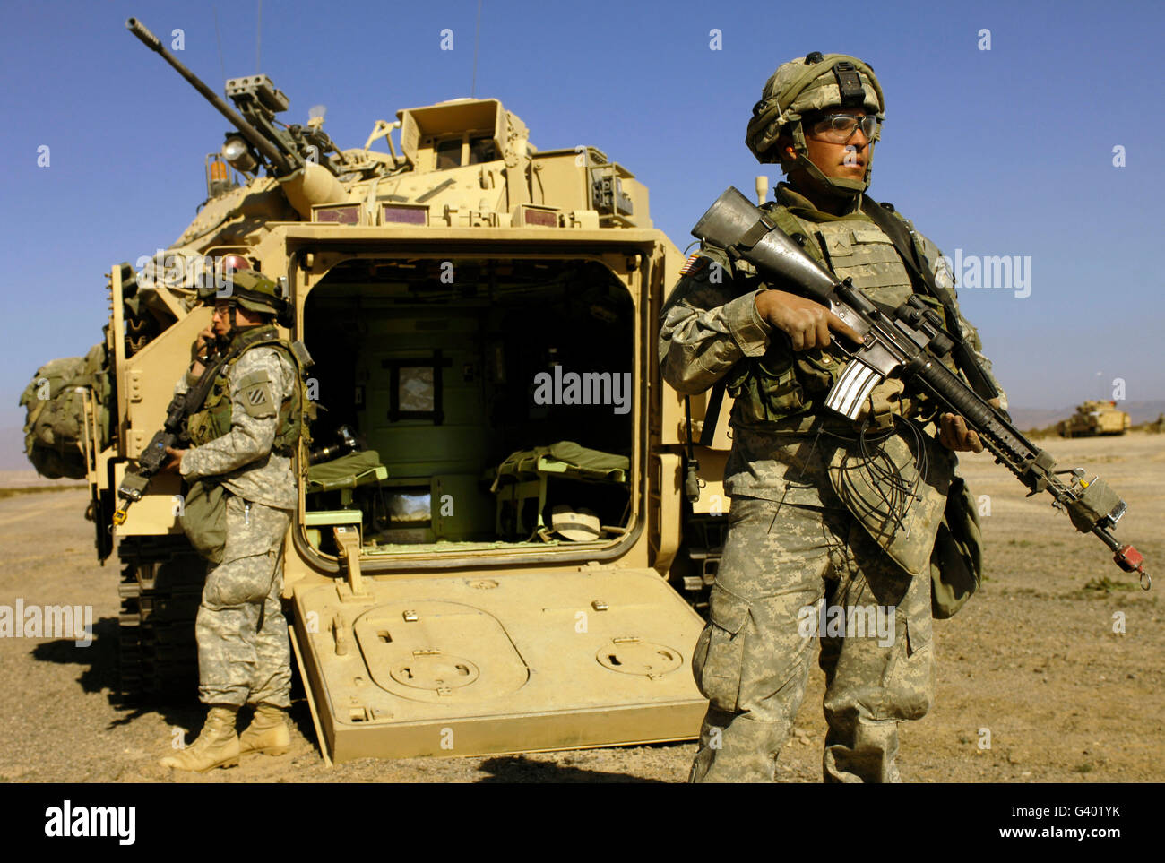 Les soldats de l'armée américaine d'assurer la sécurité d'un véhicule de combat Bradley M2. Banque D'Images
