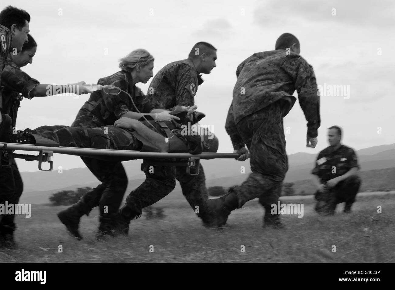 Le personnel médical multinational course pour un MI-17, avec un patient blessé. Banque D'Images