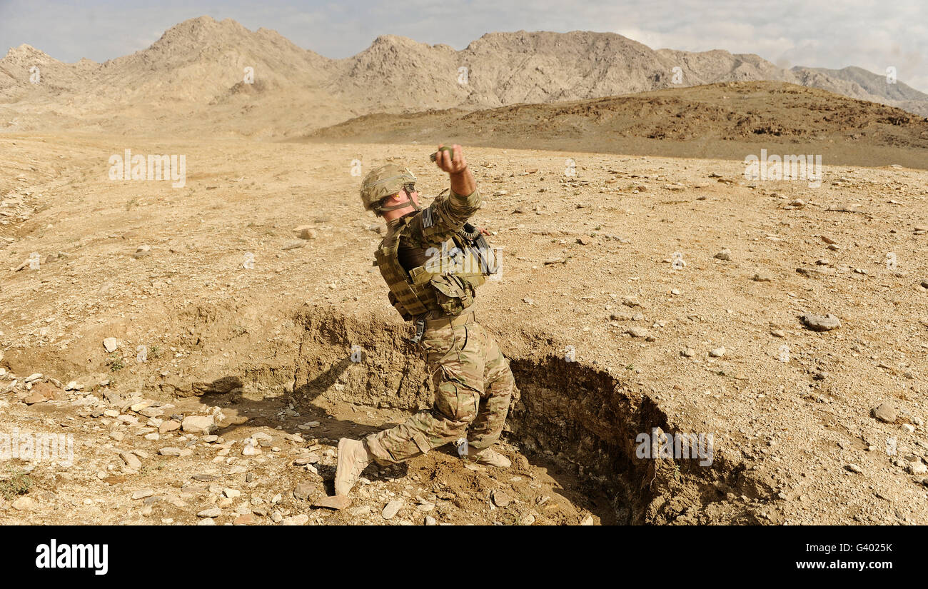 Soldat de l'US Air Force lance une grenade à fragmentation à l'extérieur de la base de tir. Banque D'Images