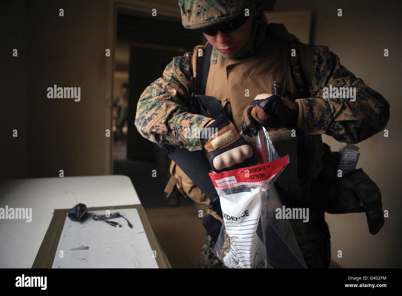 Un policier militaire recueille des matériaux utilisés pour la fabrication de bombes. Banque D'Images