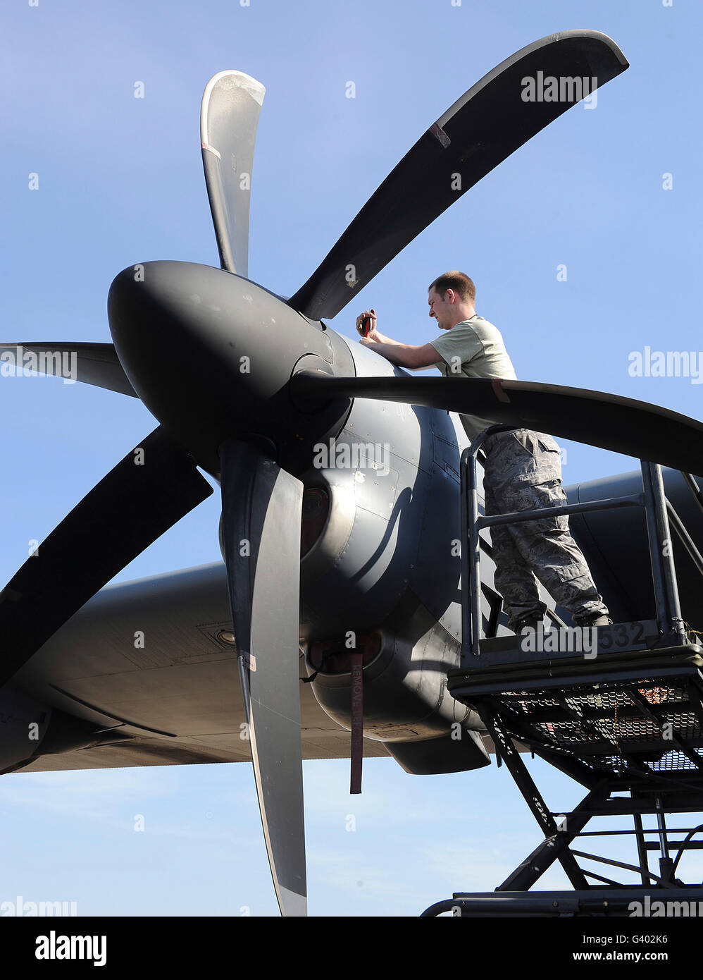 Finis le déplacement d'un mécanicien sur l'hélice du moteur un C-130J Super Hercules. Banque D'Images