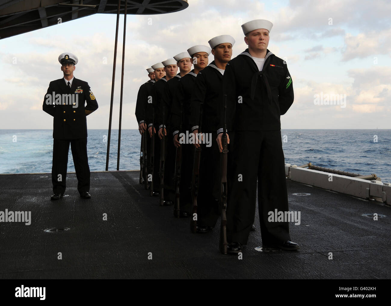 La garde d'honneur est de parade reste pendant un enterrement en mer. Banque D'Images