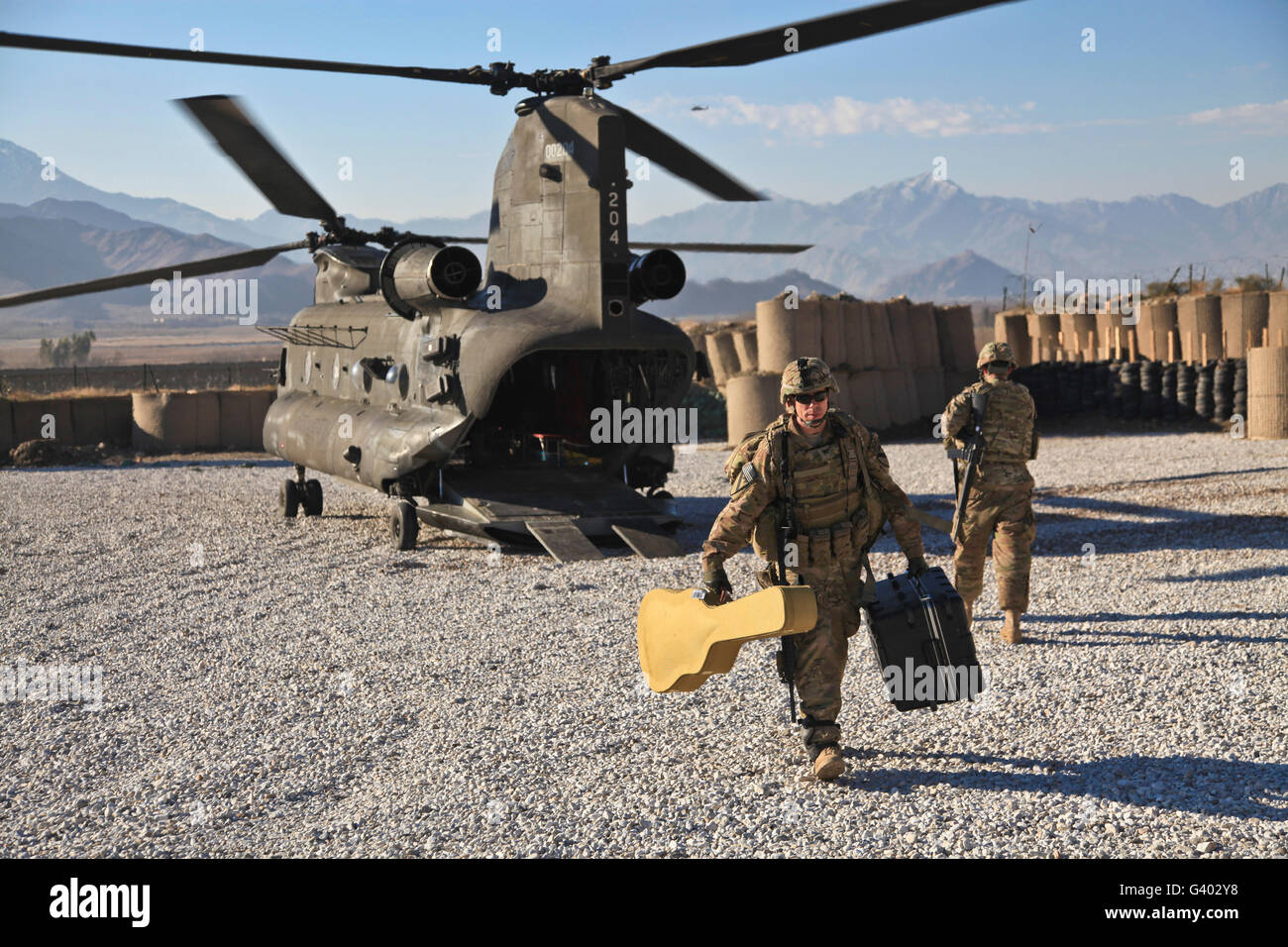 Le sergent de l'armée américaine contribue à décharger l'équipement de bande d'un CH-47 Chinook. Banque D'Images