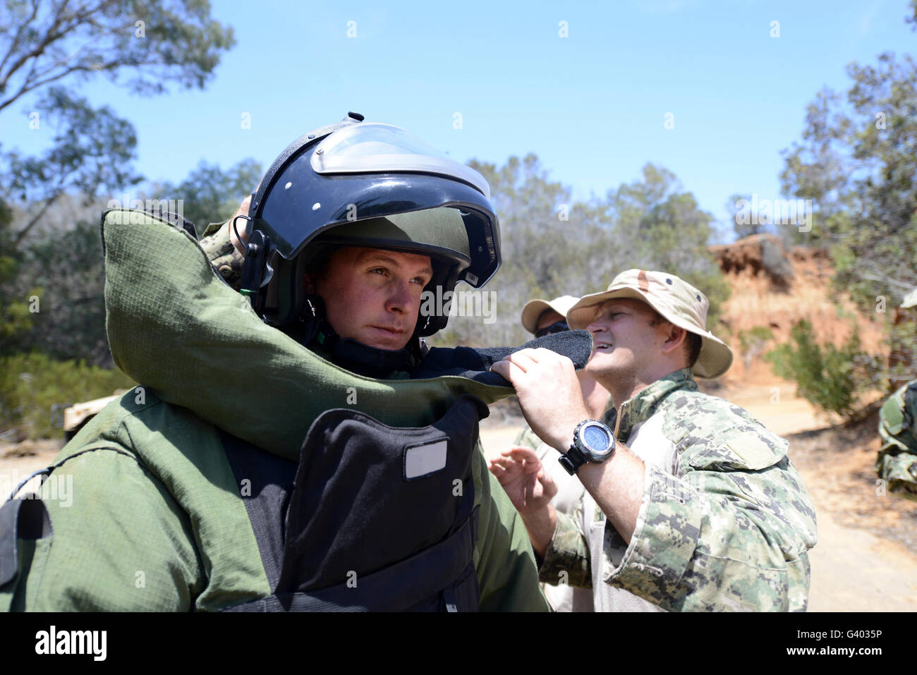 Soldat fournit de l'aide à mettre sur une combinaison antibombe. Banque D'Images