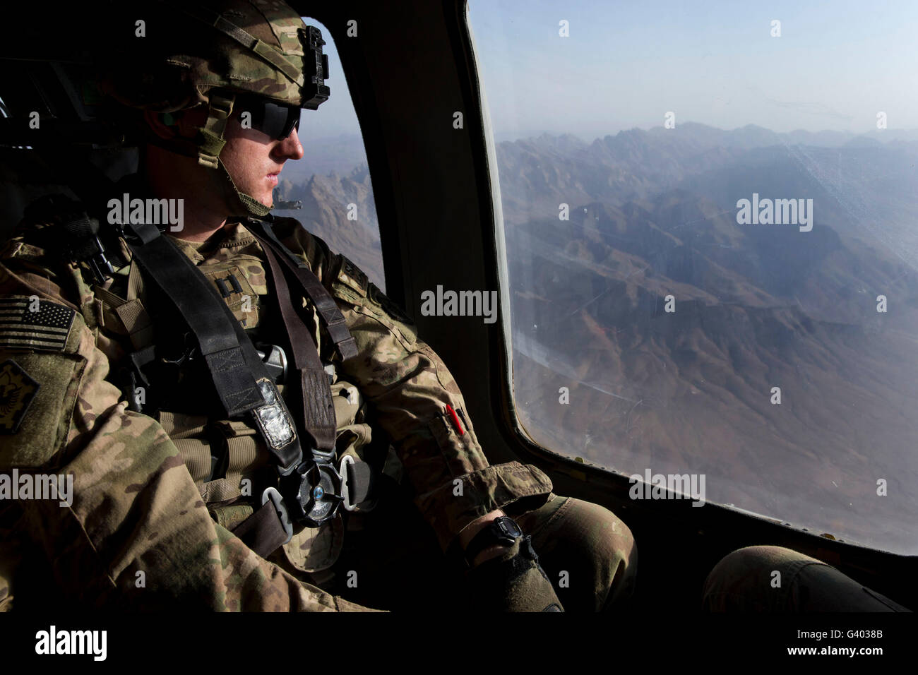 Soldat de l'armée américaine regarde par la fenêtre d'un UH-60 Black Hawk. Banque D'Images