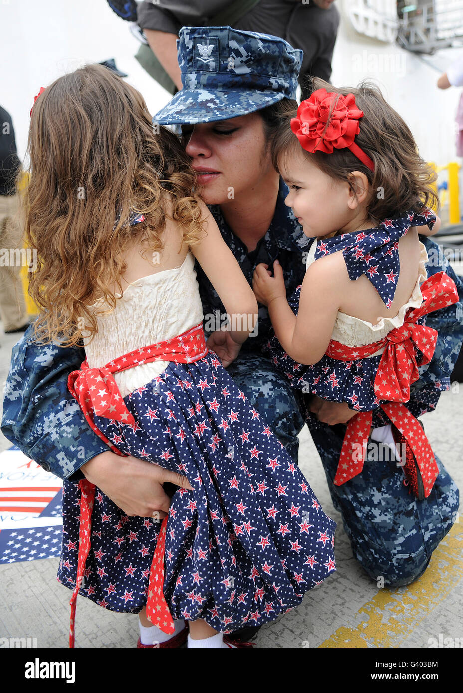 Hospital Corpsman hugs ses filles après son retour de déploiement. Banque D'Images