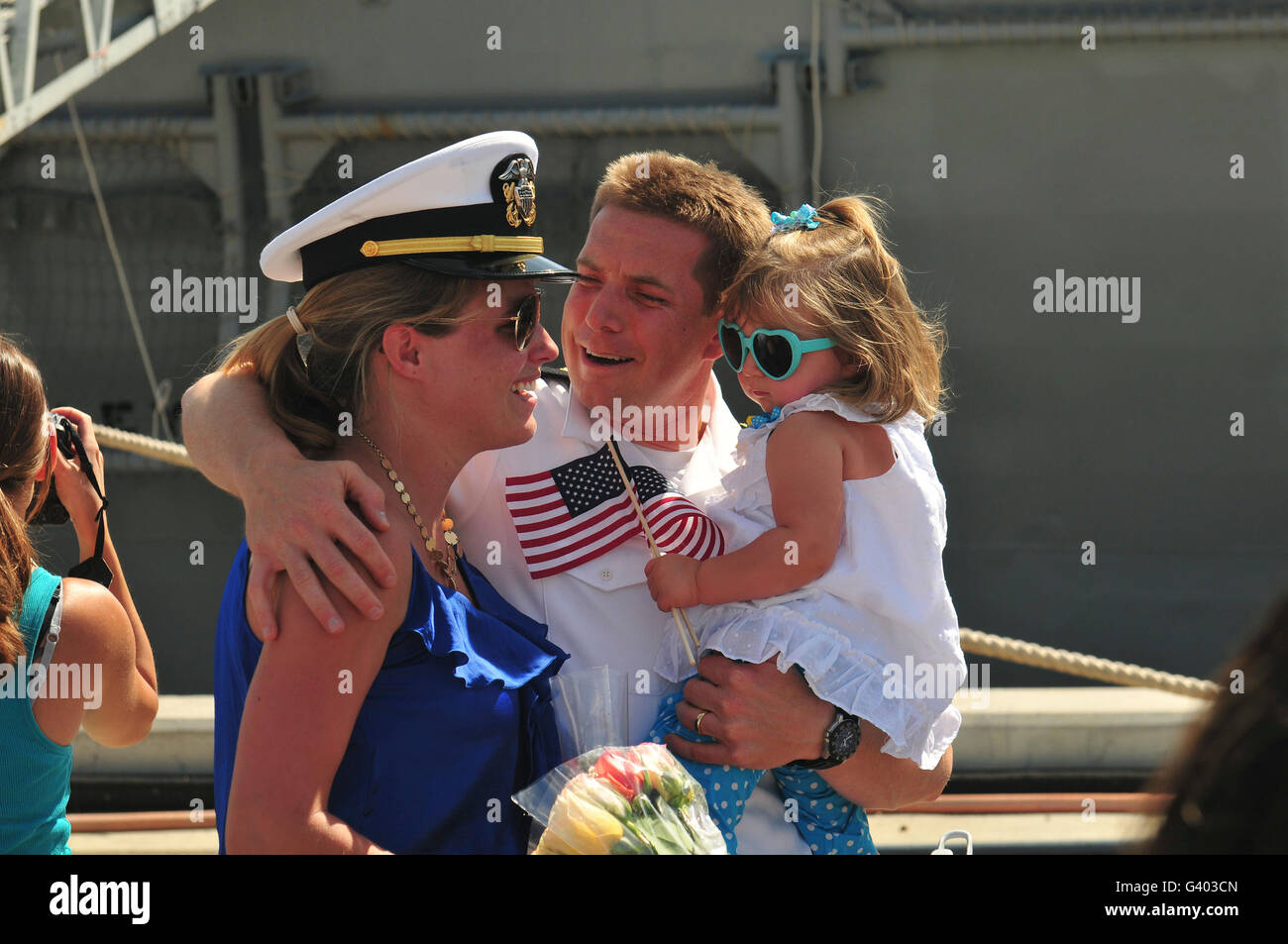 Marin de la Marine américaine est accueilli par sa femme et sa fille dans le contexte des Retrouvailles. Banque D'Images