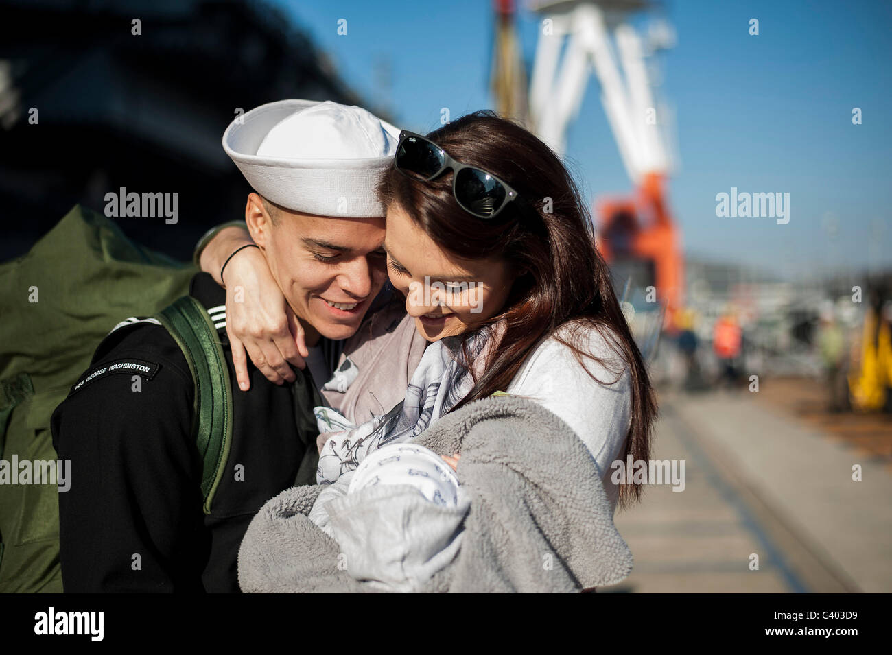 Marin de la Marine américaine épouse sa femme et l'enfant nouveau-né. Banque D'Images