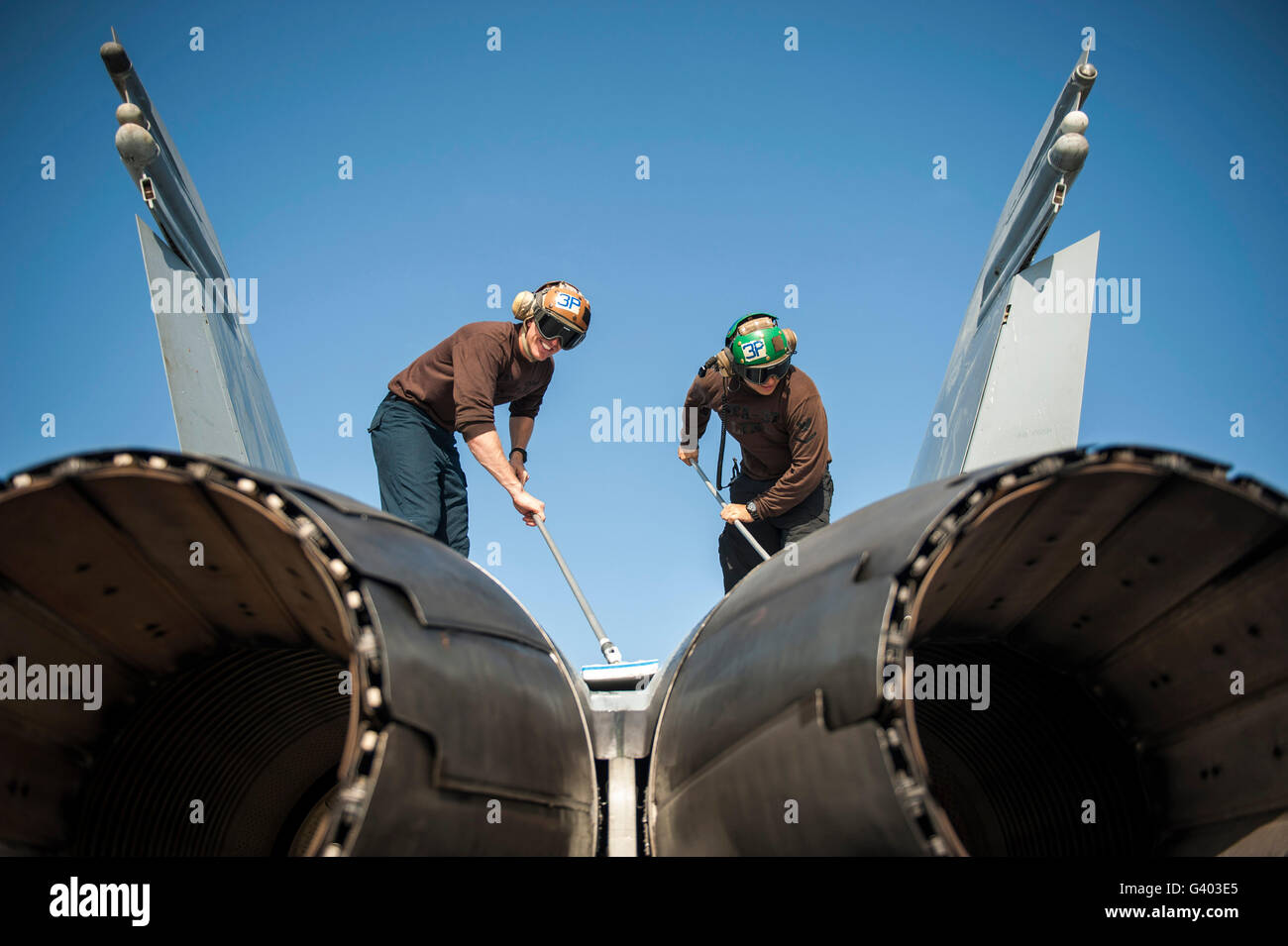 L'Machinistâ Aviation Mates nettoyer un F/A-18C Hornet. Banque D'Images