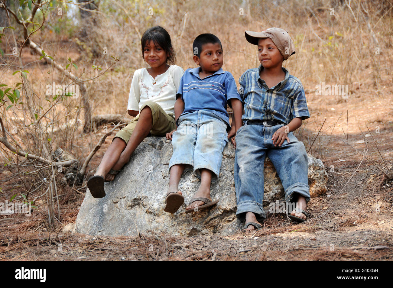 Enfants guatémaltèques assis sur un rocher à El Robles, au Guatemala. Banque D'Images