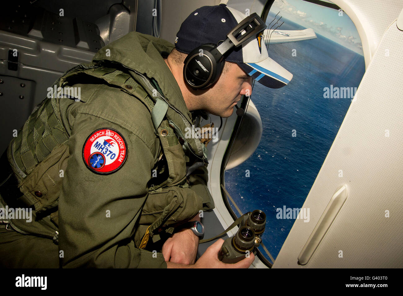 Recherches Aircrewman Naval par la fenêtre d'un P-8A Poseidon. Banque D'Images