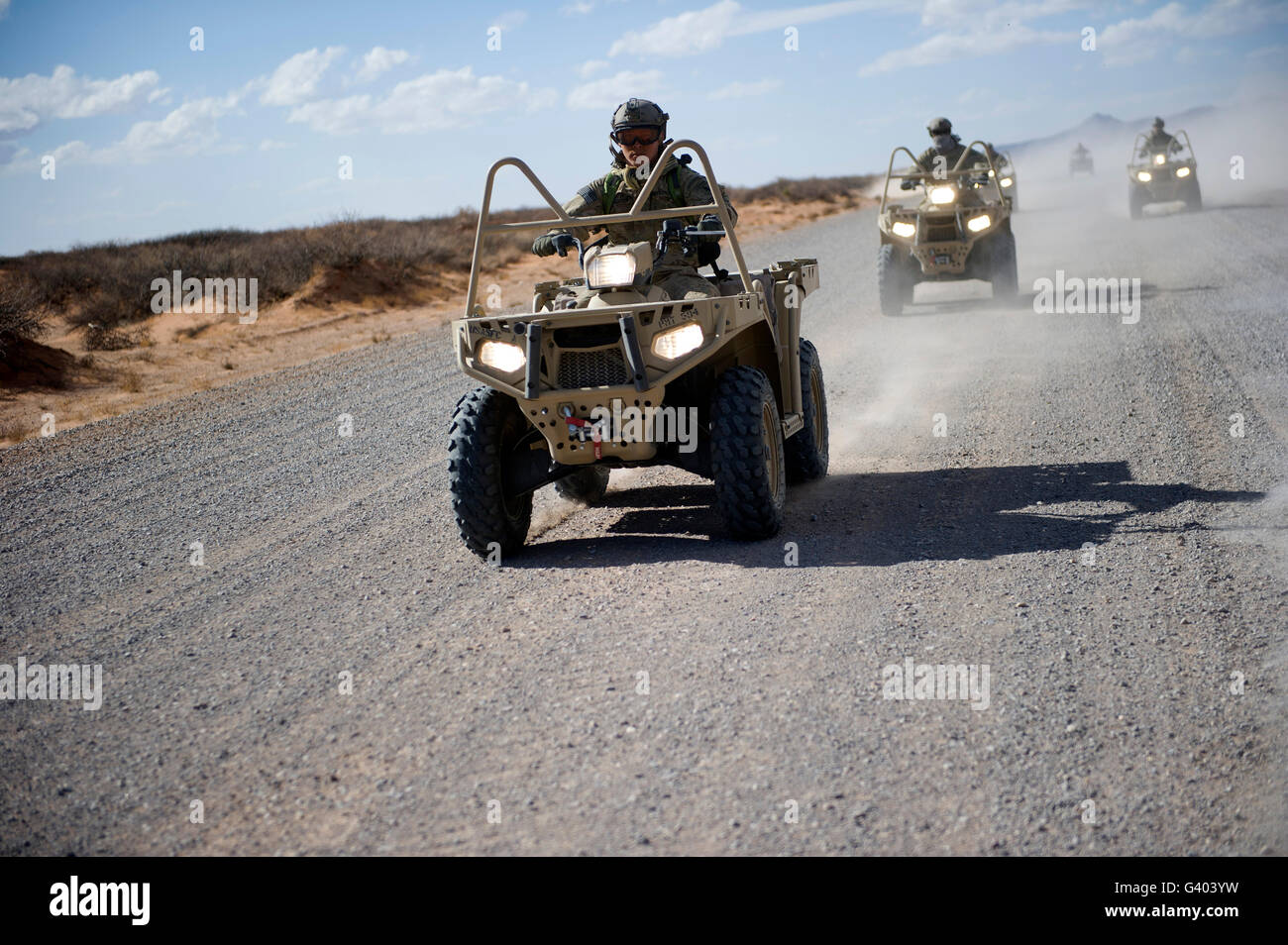 Des soldats américains d'effectuer des manoeuvres sur une route de gravier avec un LTATV. Banque D'Images