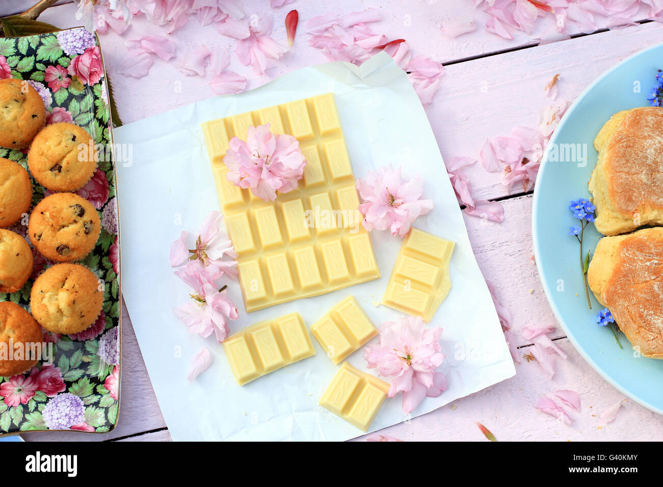 Une barre de chocolat blanc avec des muffins et des fleurs fleur de cerisier japonais Banque D'Images