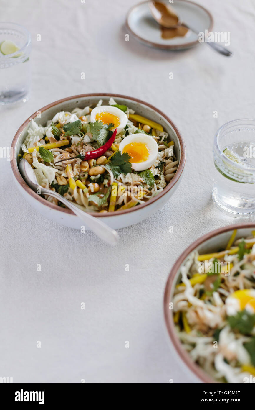 Deux bols de légumes croquants aux arachides chaude bol avec la vinaigrette est photographié à partir de la vue de face. Banque D'Images