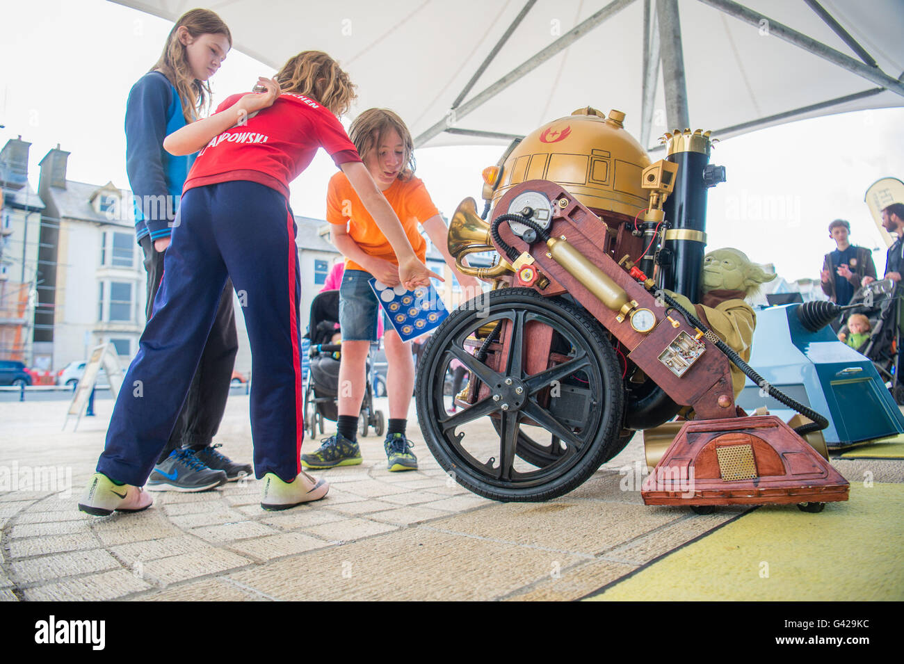 Pays de Galles Aberystwyth UK, samedi 18 juin 2016 trois enfants, potentiels futurs scientifiques, en interaction avec une équipe de "punk RD-D2' replica robot sur un bel après-midi d'été sur la promenade à Aberystwyth, Pays de Galles au Royaume-Uni. Tout au long de la journée, l'Université d'Aberystwyth Intelligent Robotics Group (IRG) démontrent certains de leurs projets, aux côtés des mini-robots créés par des enfants des écoles locales à l'hebdomadaire La robotique Aberystwyth Club, un club pour les 11-18 ans, gérés par le département crédit photo : Keith Morris/Alamy Live News Banque D'Images