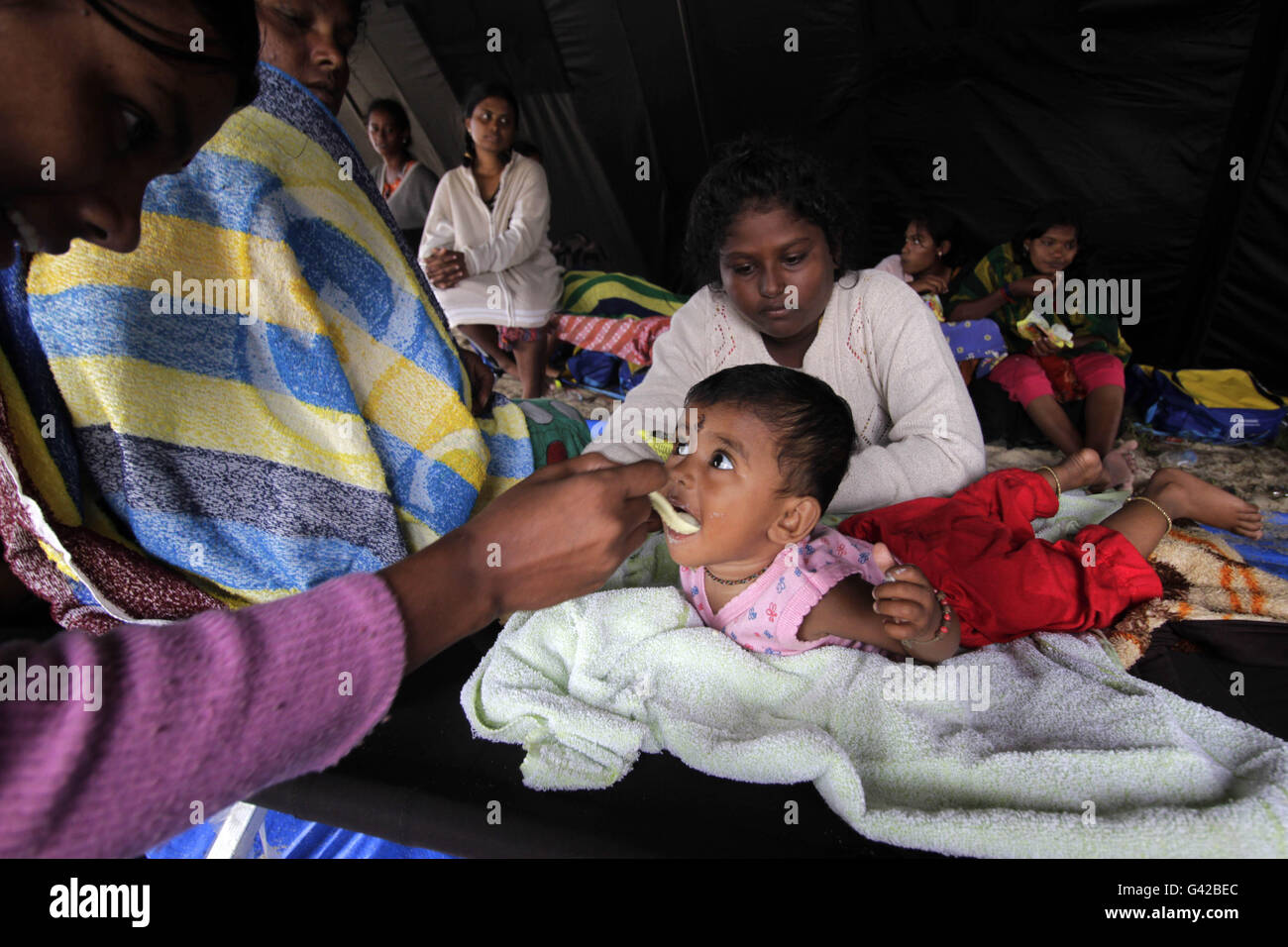 Aceh, Indonésie. 18 Juin, 2016. Sri Lanka Une femme nourrit son bébé à l'abri temporaire mis en place le long de la plage tandis que les militaires de l'Indonésie essayer de corriger l'embarcation échouée à Lhoknga beach, Indonésie, le 18 juin 2016. Des dizaines d'immigrants d'avoir été Sri-Lankais échoués dans Lhoknga dans le district d'Aceh Besar, l'Indonésie en raison de la rupture de leur bateau moteur, les médias locaux ici rapportés récemment. Credit : Junaidi/Xinhua/Alamy Live News Banque D'Images