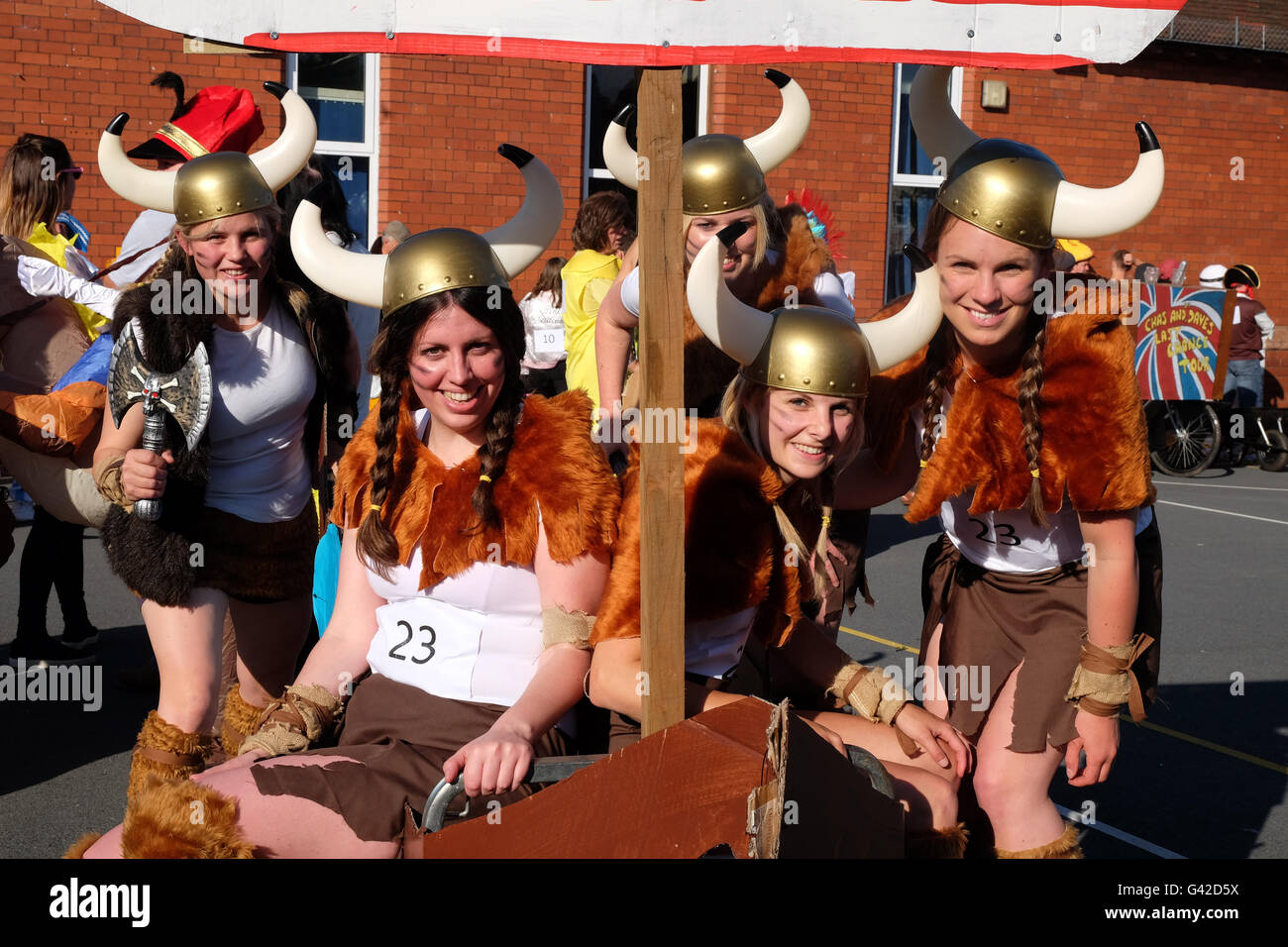 Kington, Herefordshire, UK - Samedi 18 Juin 2016 - le pouvoir aux filles une équipe de jeune dame Vikings se préparer à participer à la 40e marche de la course de brouettes Kington annuel. Concurrents course autour de la ville dans la soirée et s'arrêter de boire une demi-pinte de bière à chacun des pubs autour de la ville. Banque D'Images