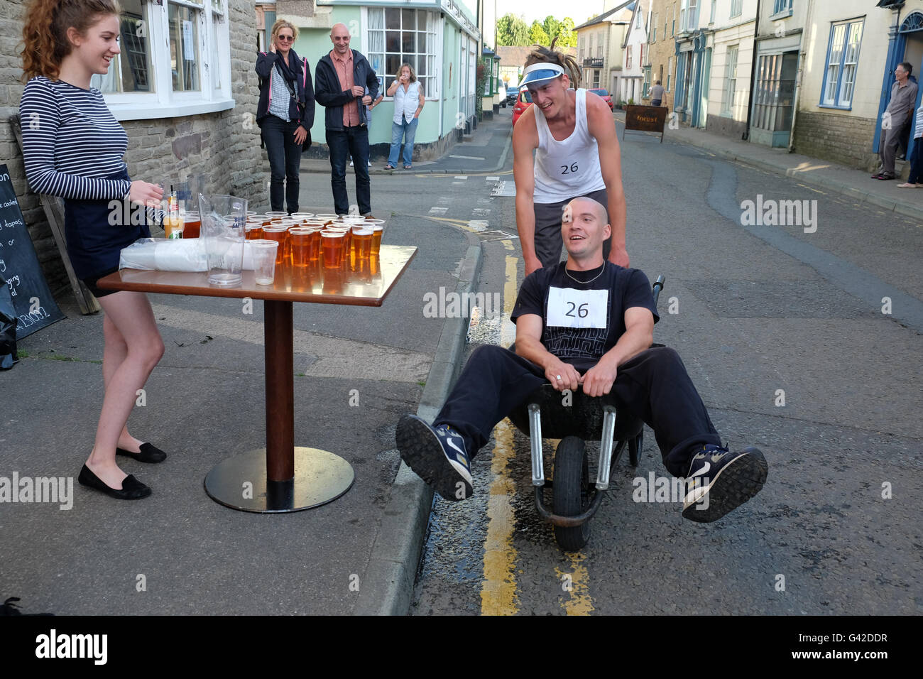 Kington, Herefordshire, UK - Samedi 18 Juin 2016 - Une équipe arrivent épuisés à la prochaine bière pub arrêter lors de la 40e assemblée annuelle de la course de brouettes Kington. Concurrents course autour de la ville dans la soirée et s'arrêter de boire une demi-pinte de bière à chacun des pubs autour de la ville. Banque D'Images