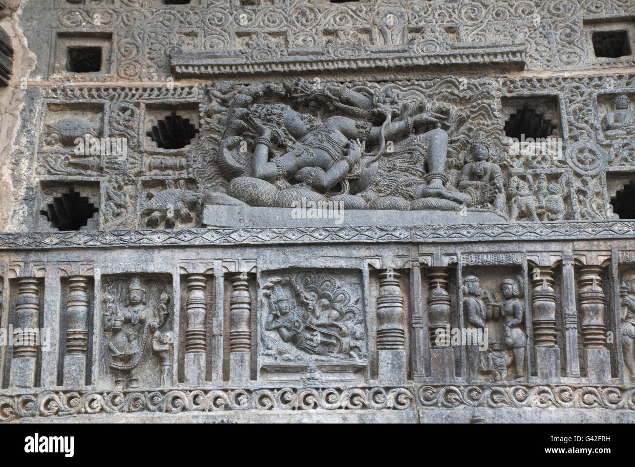 Perforé orné fenêtre. Une sculpture de Vishnu Sheshashayee avec son épouse, Lakshmi. Temple Chennakeshava, Belur, Karnataka, Banque D'Images