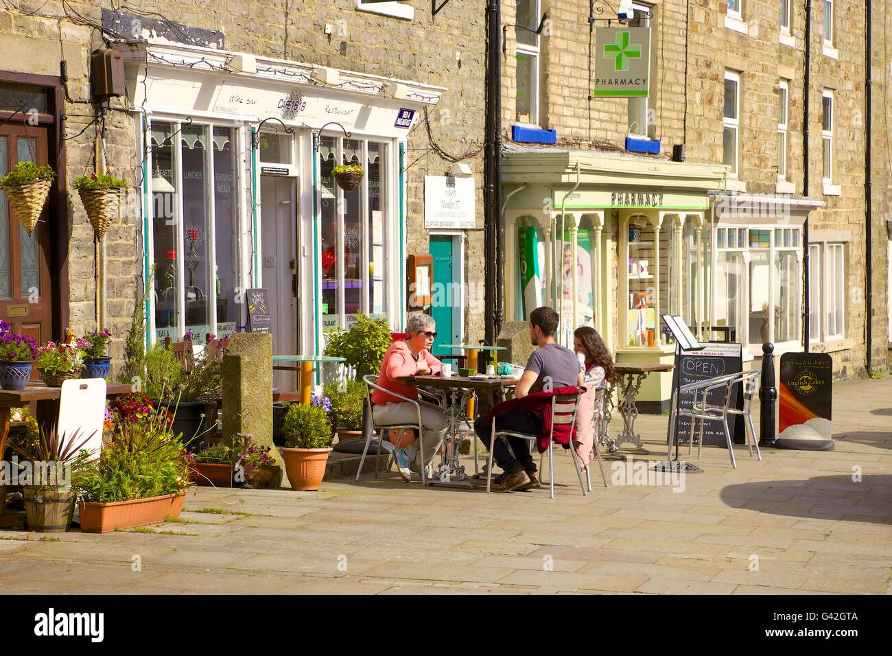 Les gens assis à l'extérieur d'un café. Cafe1618,16 Market Place, Middleton-in-Teesdale, County Durham, Angleterre, Royaume-Uni, Europe. Banque D'Images