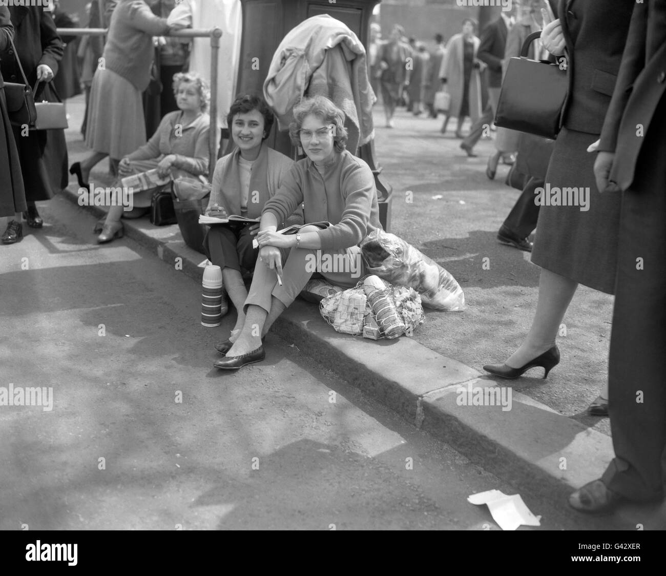 Déterminés à attendre la nuit, les Sud-Africains Peggy Stockenstroom, à gauche, et Ann Donald, s'installent eux-mêmes et leur équipement sur le trottoir dans le Mall. Ils assurent une vue de première rangée de la princesse Margaret lorsqu'elle passe sur le chemin de l'abbaye de Westminster pour son mariage à Antony Armstrong-Jones Banque D'Images