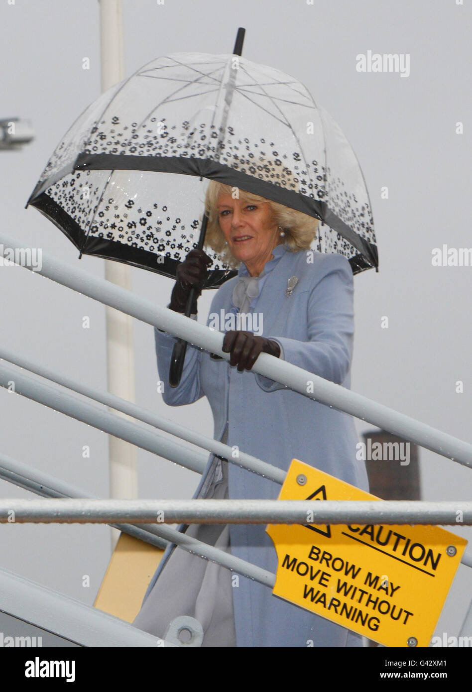 La Duchesse de Cornwall abrite sous un parapluie alors qu'elle négocie le gangway après son arrivée pour une visite à bord du navire auxiliaire de la flotte royale, RFA Argus, pour voir les installations et rencontrer le personnel du navire-hôpital, à la base navale royale de Portsmouth. Banque D'Images