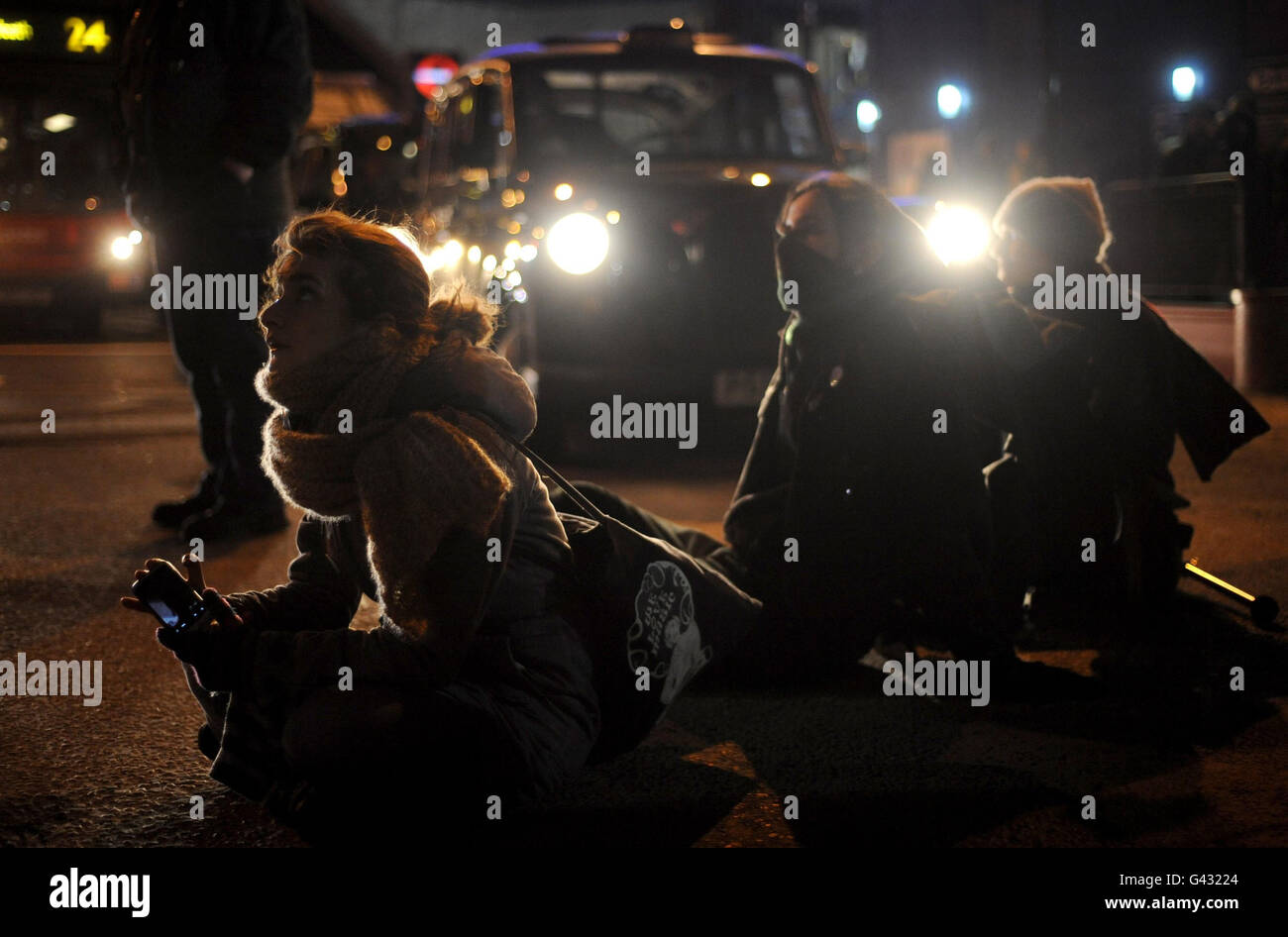 Les manifestants s'assoient au carrefour d'Oxford Street pour protester contre une augmentation des frais de scolarité dans le centre de Londres. Banque D'Images