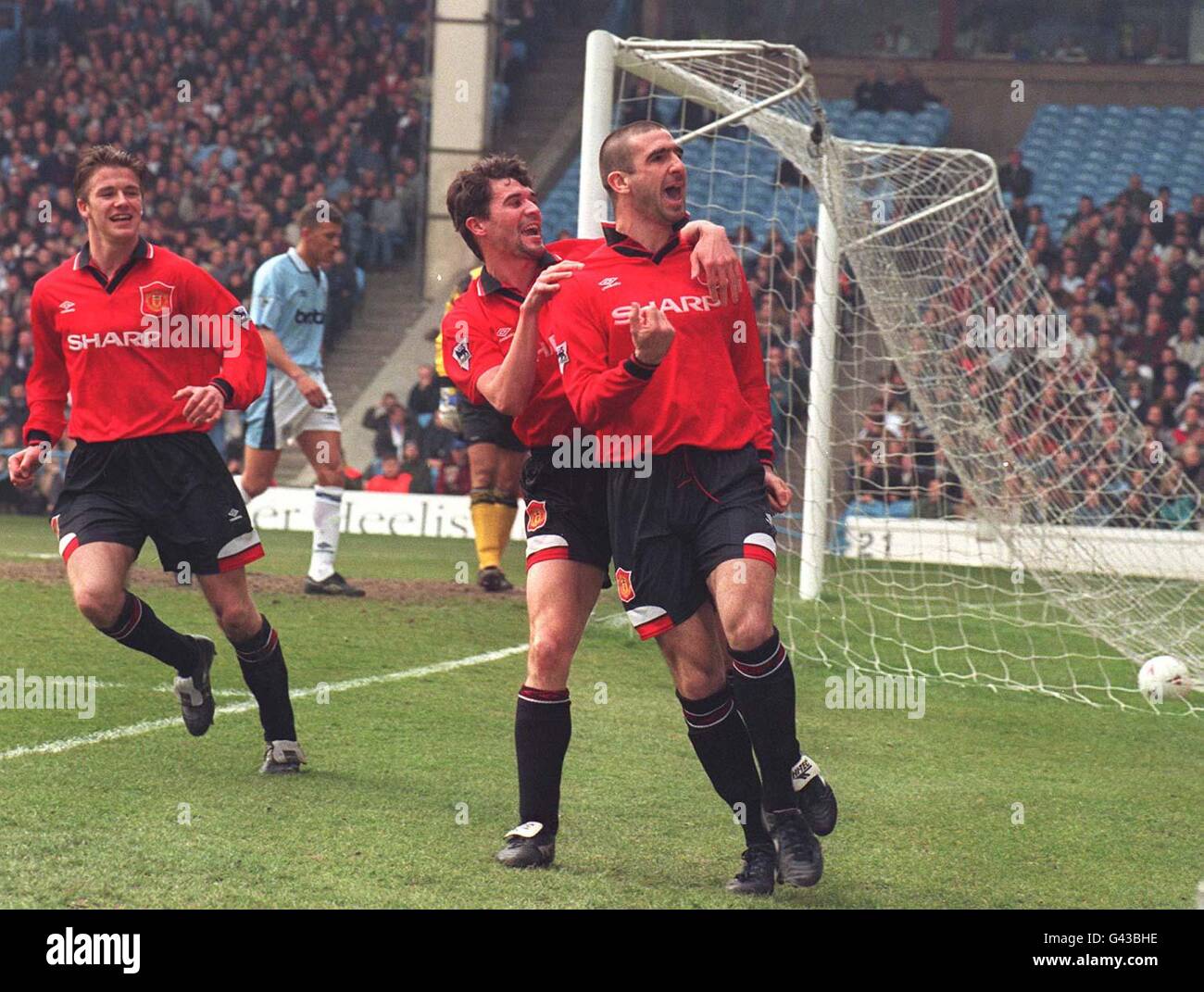 Eric Cantona (à droite) trouve le dos du filet à nouveau comme il ouvre la notation pour Manchester United contre Manchester City dans le Premiership. Banque D'Images